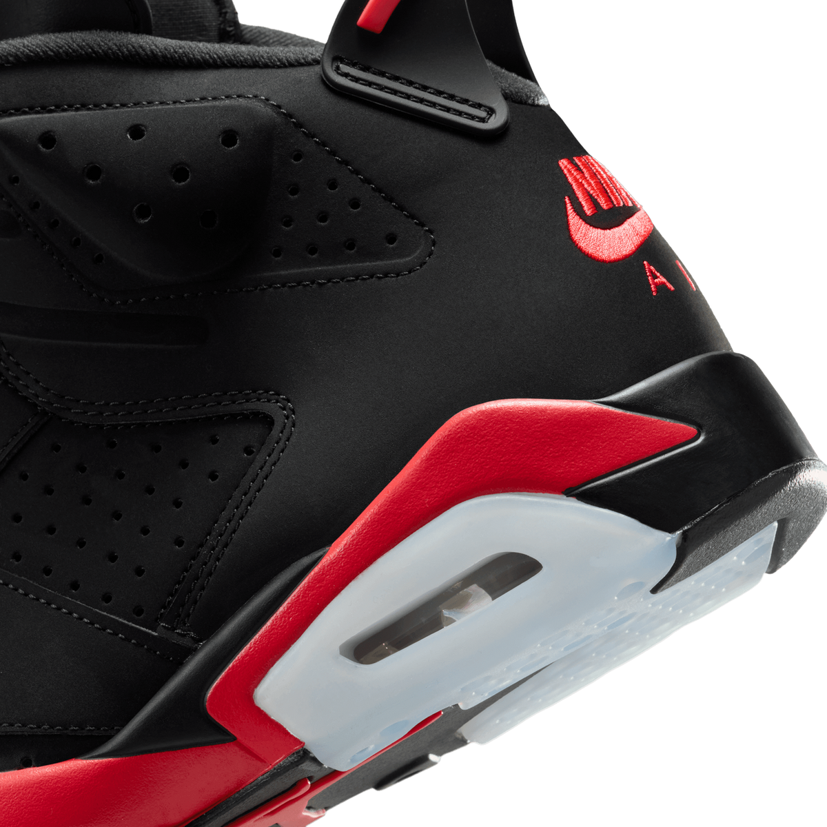 Close-up of a black Jordan 6 heel showing the red embroidered Nike Air logo, perforated black overlay, and red and translucent heel tab with visible air unit.