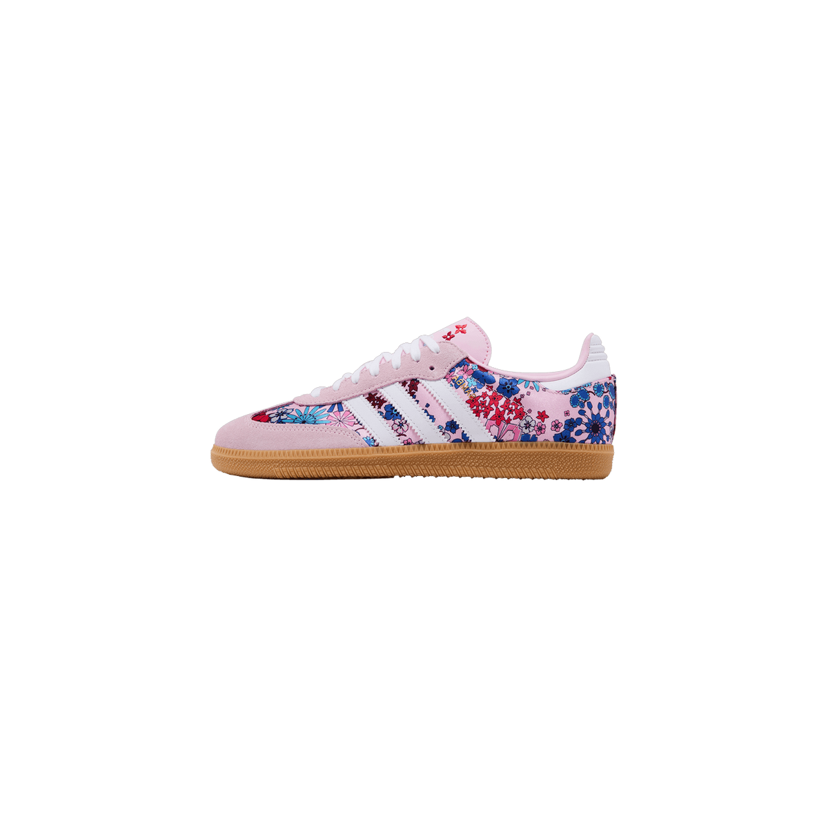 Side view of an Adidas Samba sneaker with pink suede overlays, white stripes, gum sole, and a multicolor floral print covering the toe box and heel
