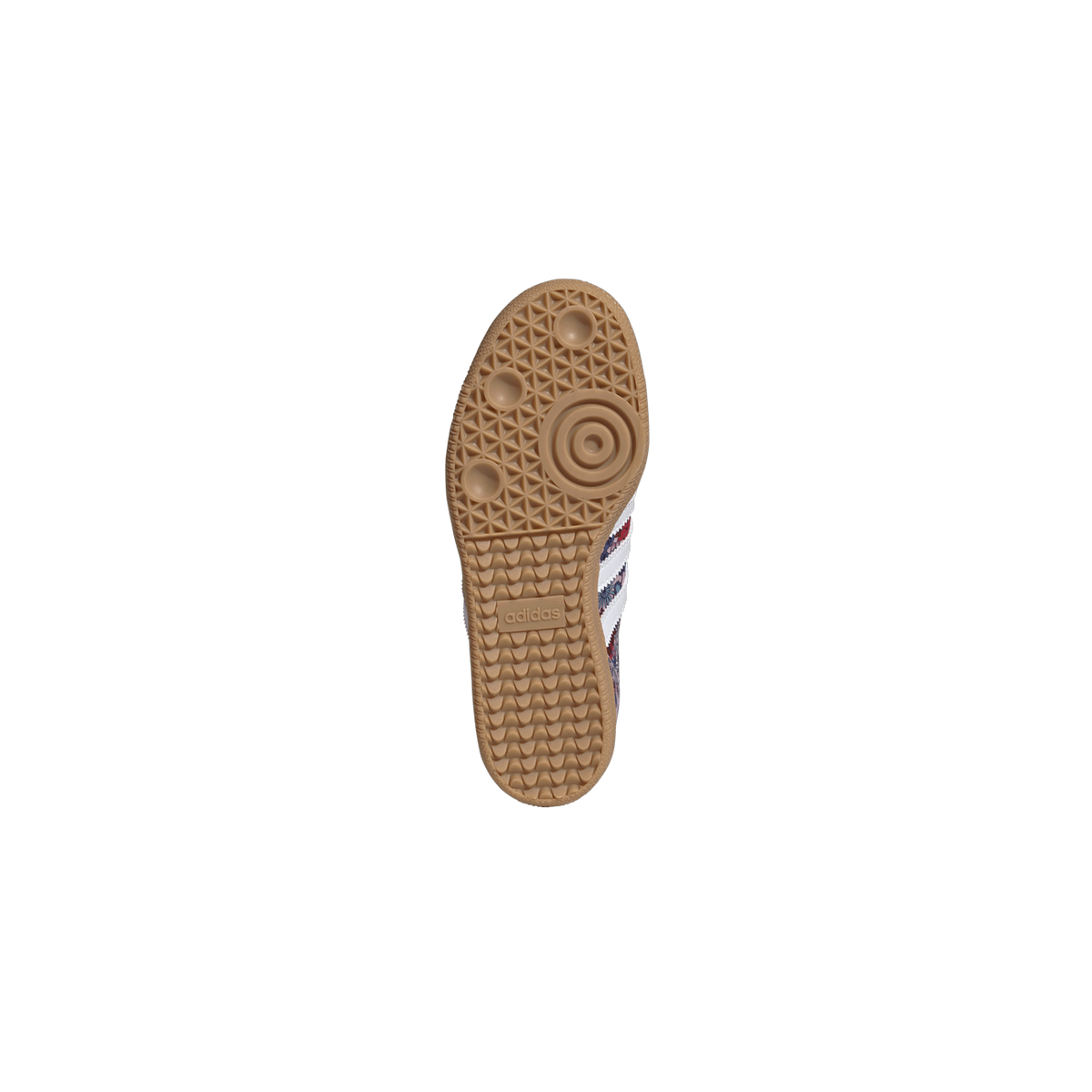 Bottom view of an Adidas Samba sneaker showing a tan gum rubber outsole with adidas branding and a floral multicolor upper visible along the edge.