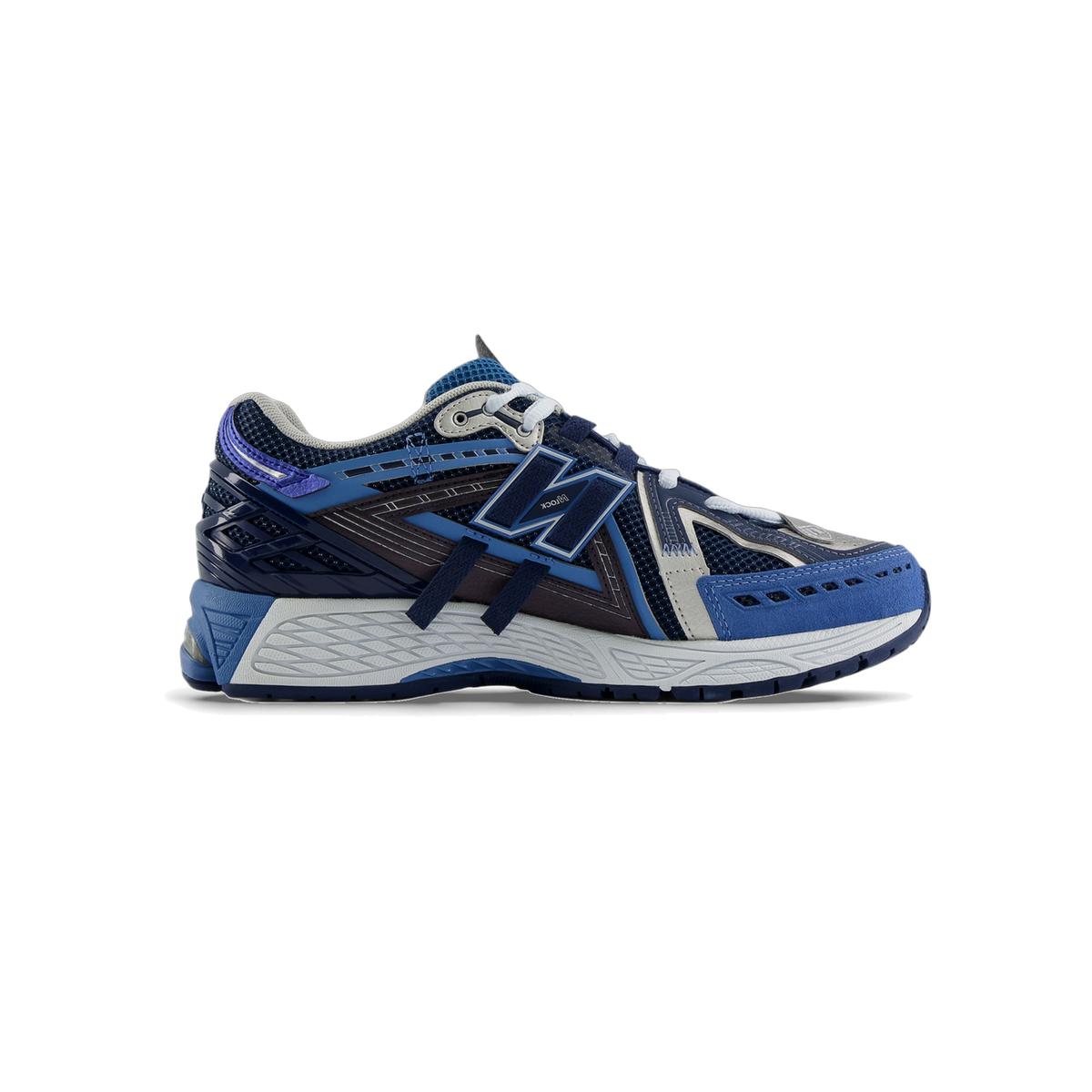 Side view of a navy and blue New Balance 1906A sneaker with a large N logo, grey outsole, and purple accents near the heel, toe pointing left.