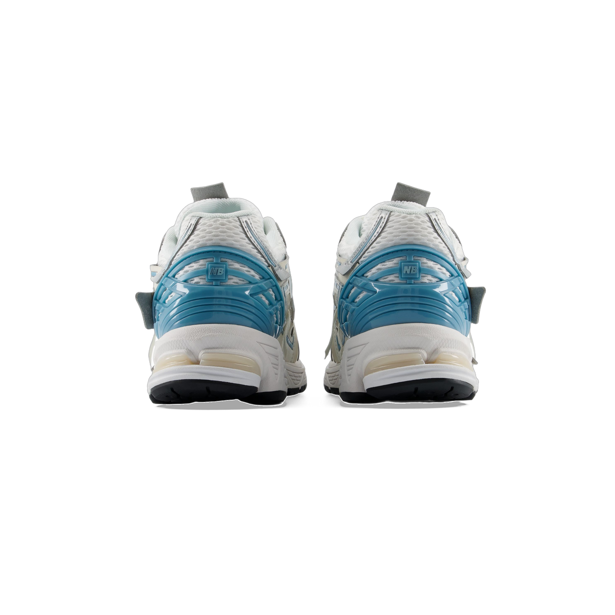 Rear view of a pair of white New Balance 1906A sneakers with blue heel counters featuring NB logo and mesh upper
