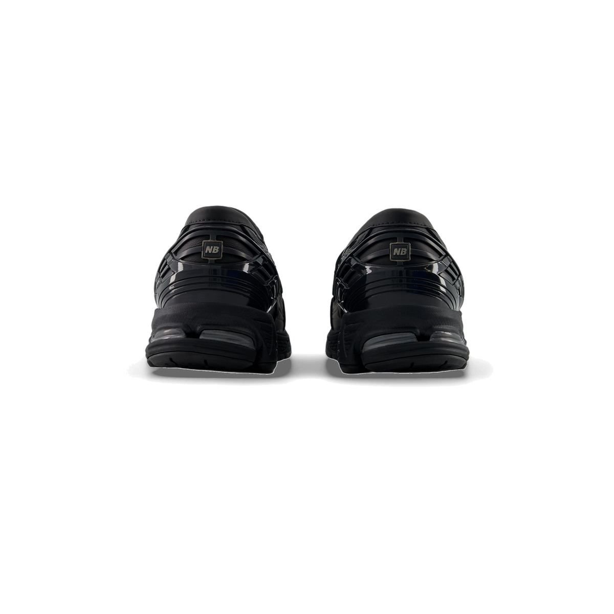 Rear view of a pair of black New Balance 1906L sneakers showing ribbed heel panels with NB logo tabs and chunky soles