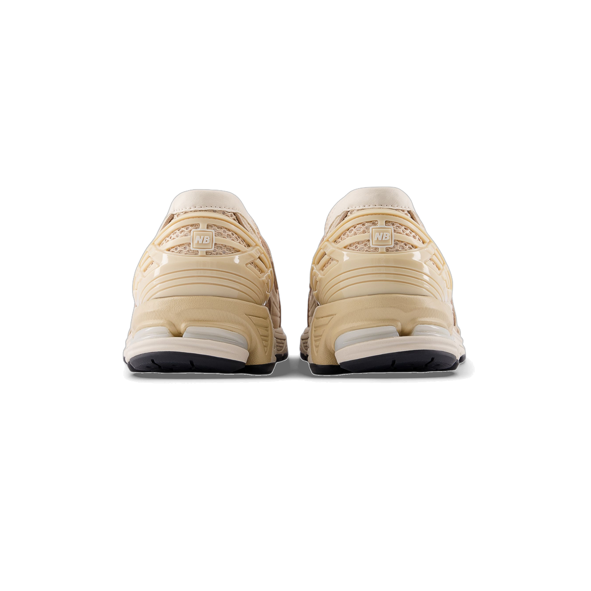 Rear view of a pair of beige and brown New Balance 1906L sneakers showing the heel panels with NB logo tabs and black outsoles.