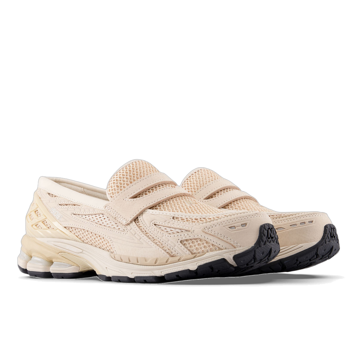 Pair of beige New Balance 1906L slip-on sneakers with mesh uppers, strap detailing, and black outsoles, angled toward the left