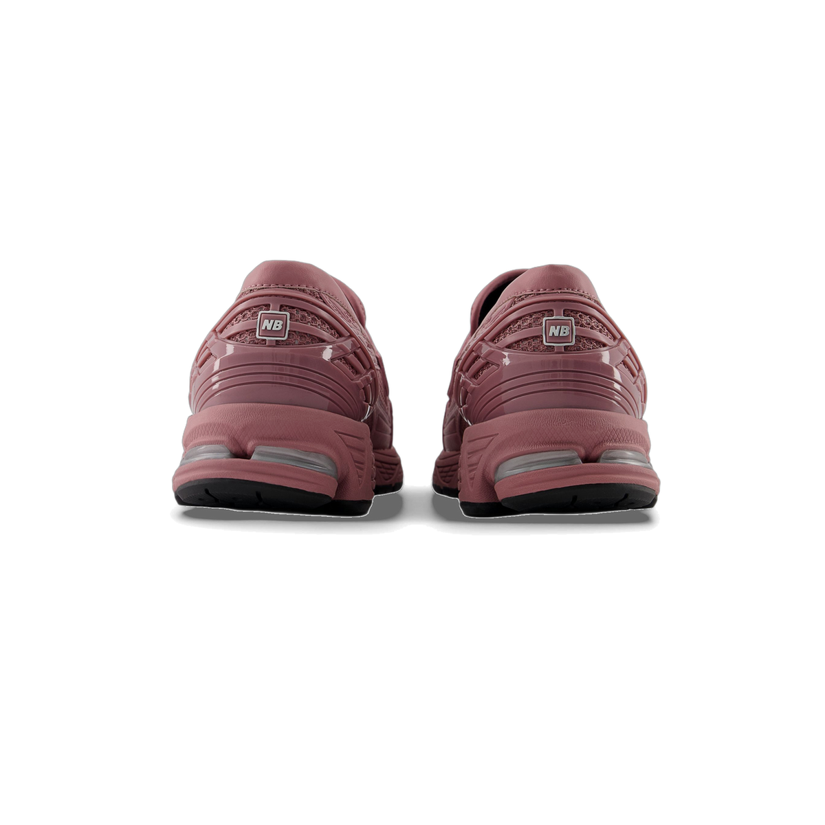 Rear view of a pair of pink-rose New Balance 1906L sneakers showing the heel pull tabs with NB logo and black outsoles