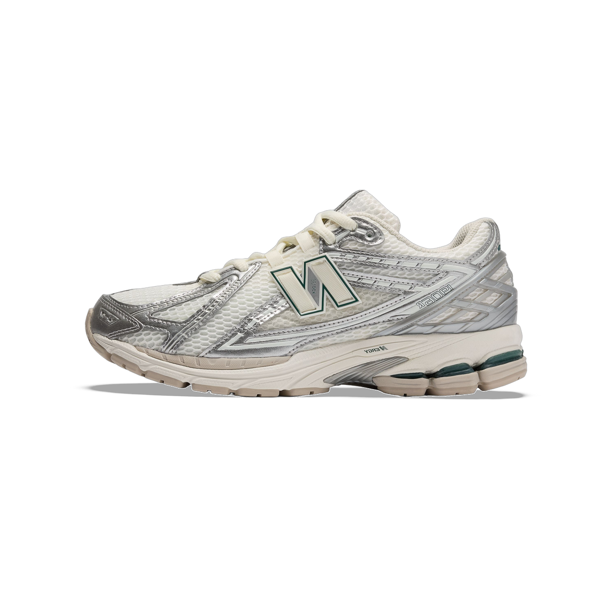 Side view of a New Balance 1906R sneaker in white and silver metallic mesh with a cream and green N logo and off-white midsole with dark green accents on the outsole.