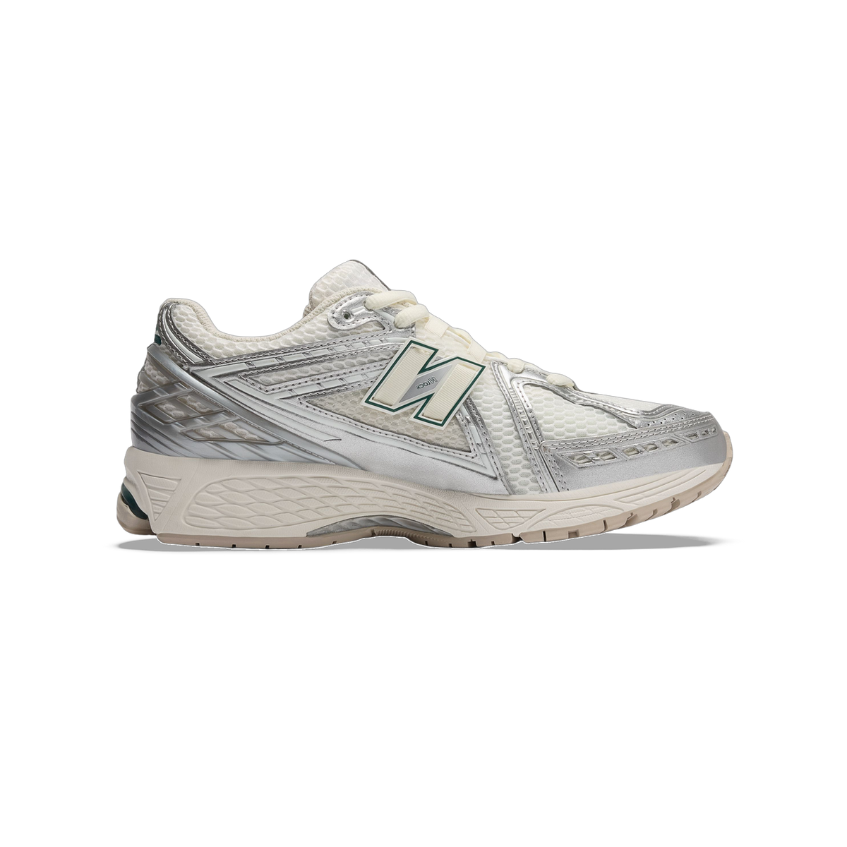 Lateral view of a New Balance 1906R sneaker in white mesh and metallic silver overlays with a cream and green N logo and off-white sole.