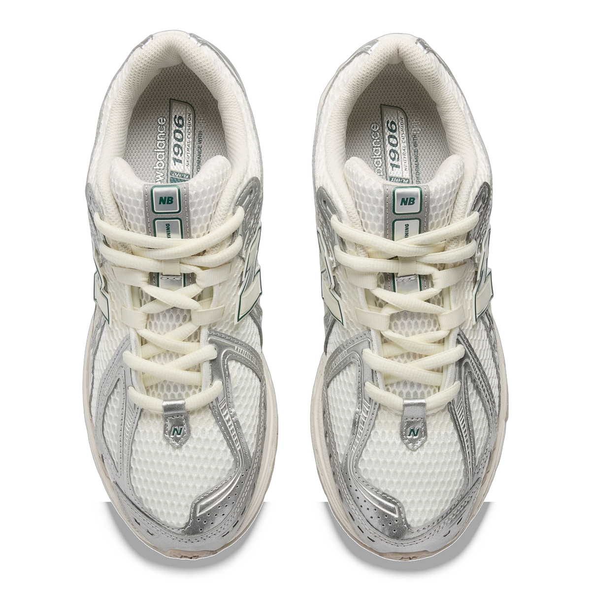 Top-down view of a pair of New Balance 1906R sneakers in white mesh with silver metallic overlays, cream laces, and green accent tabs.