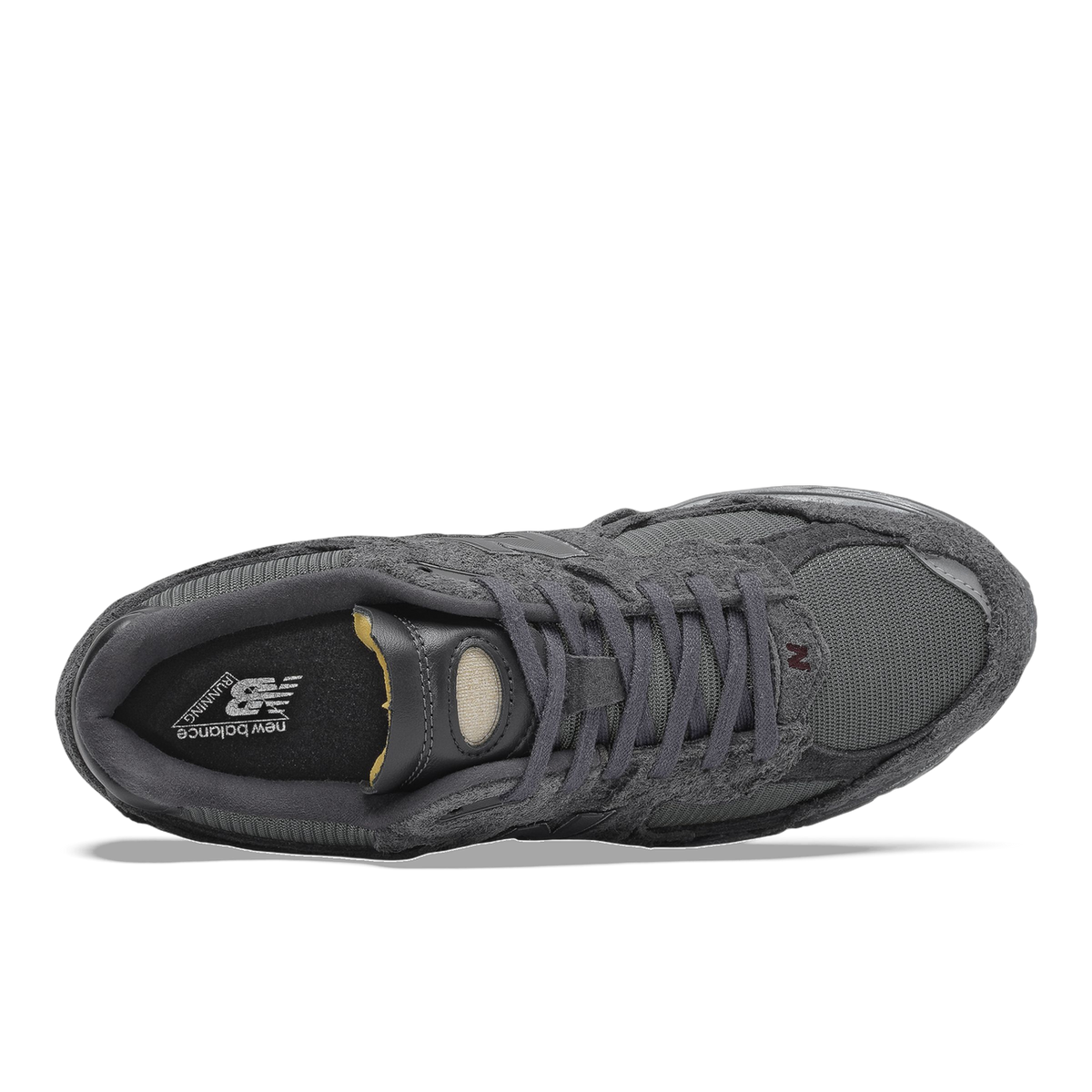 Top-down view of a gray New Balance 2002R sneaker showing suede and mesh panels, black tongue with New Balance running logo, and laces