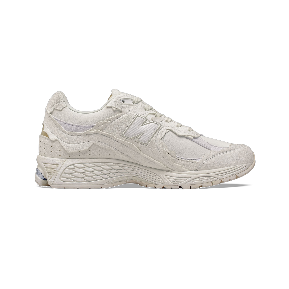 Side view of a white New Balance 2002R sneaker with textured suede overlays, mesh panels, and a chunky white sole.