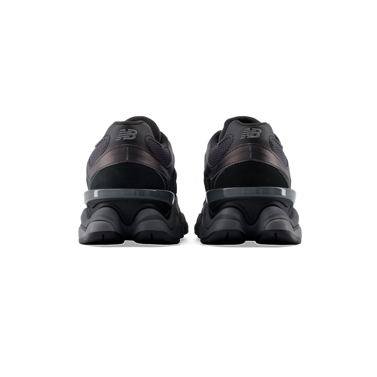 Rear view of a pair of black New Balance 9060 sneakers showing the heel logos and gray N-shaped heel clips over chunky black midsoles.