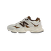 Side view of a cream and brown New Balance 9060 sneaker with a dark brown N logo and chunky off-white midsole.