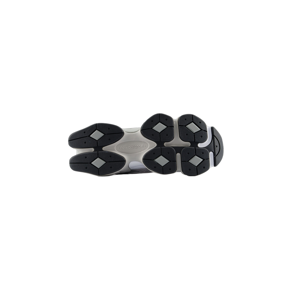 Bottom view of a New Balance 9060 sneaker showing the black lug outsole with diamond-shaped tread pattern and New Balance logo molded into the beige midsole.