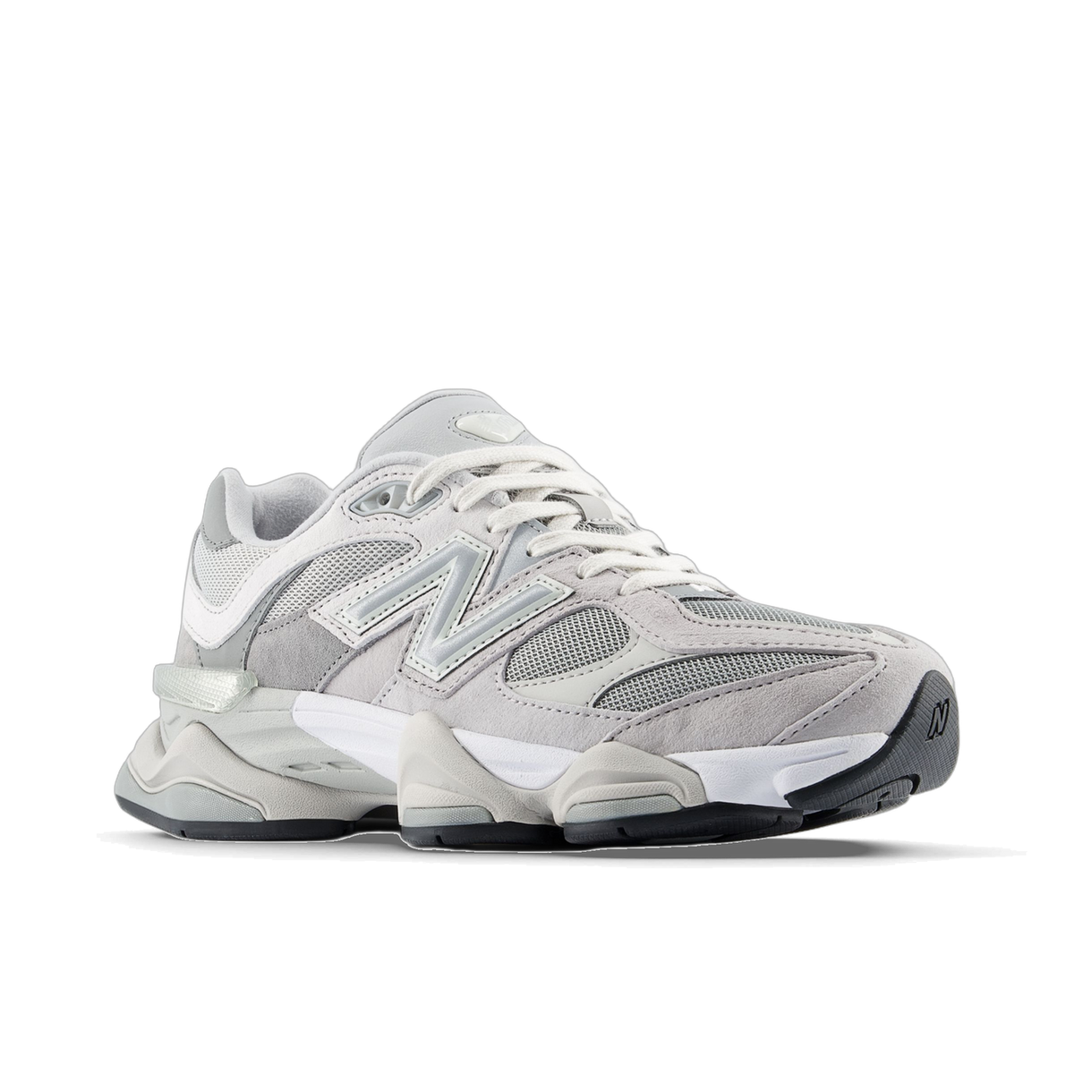 Gray New Balance 9060 sneaker shown from the side with toe pointing left, featuring suede and mesh panels, a silver N logo, white laces, and a chunky white and gray midsole with black outsole.