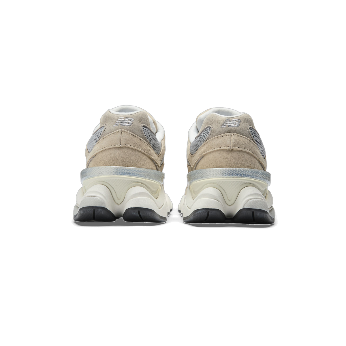Rear view of a pair of New Balance 9060 sneakers in tan and beige suede with grey mesh panels, cream chunky midsoles, and black outsoles.