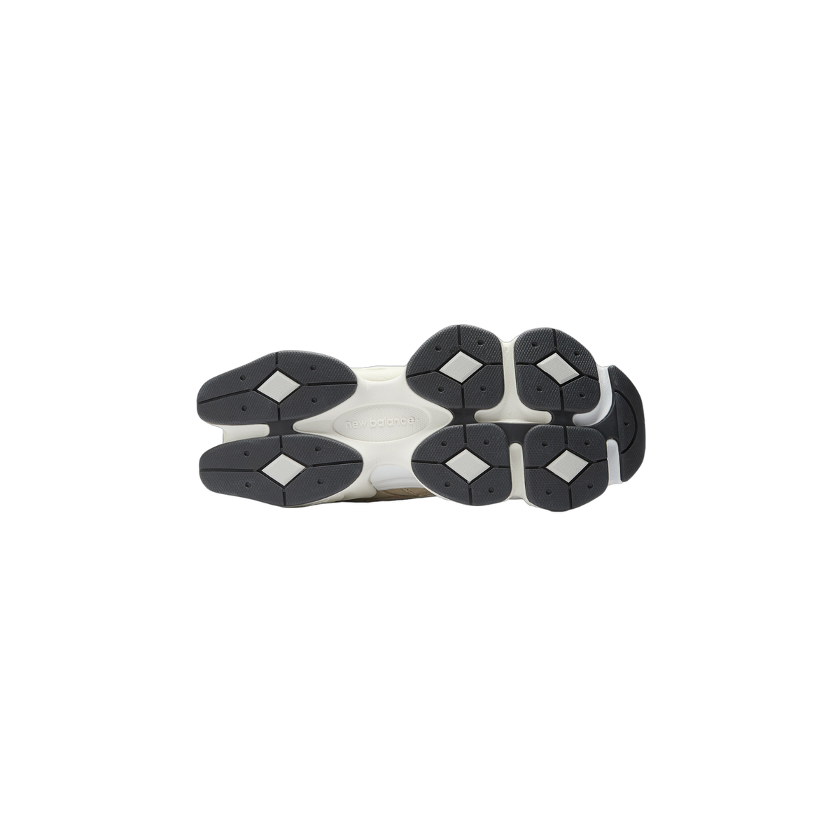 Bottom view of a pair of New Balance 9060 sneakers showing the white midsole with diamond-patterned dark gray outsole lugs and New Balance logo embossed in the center
