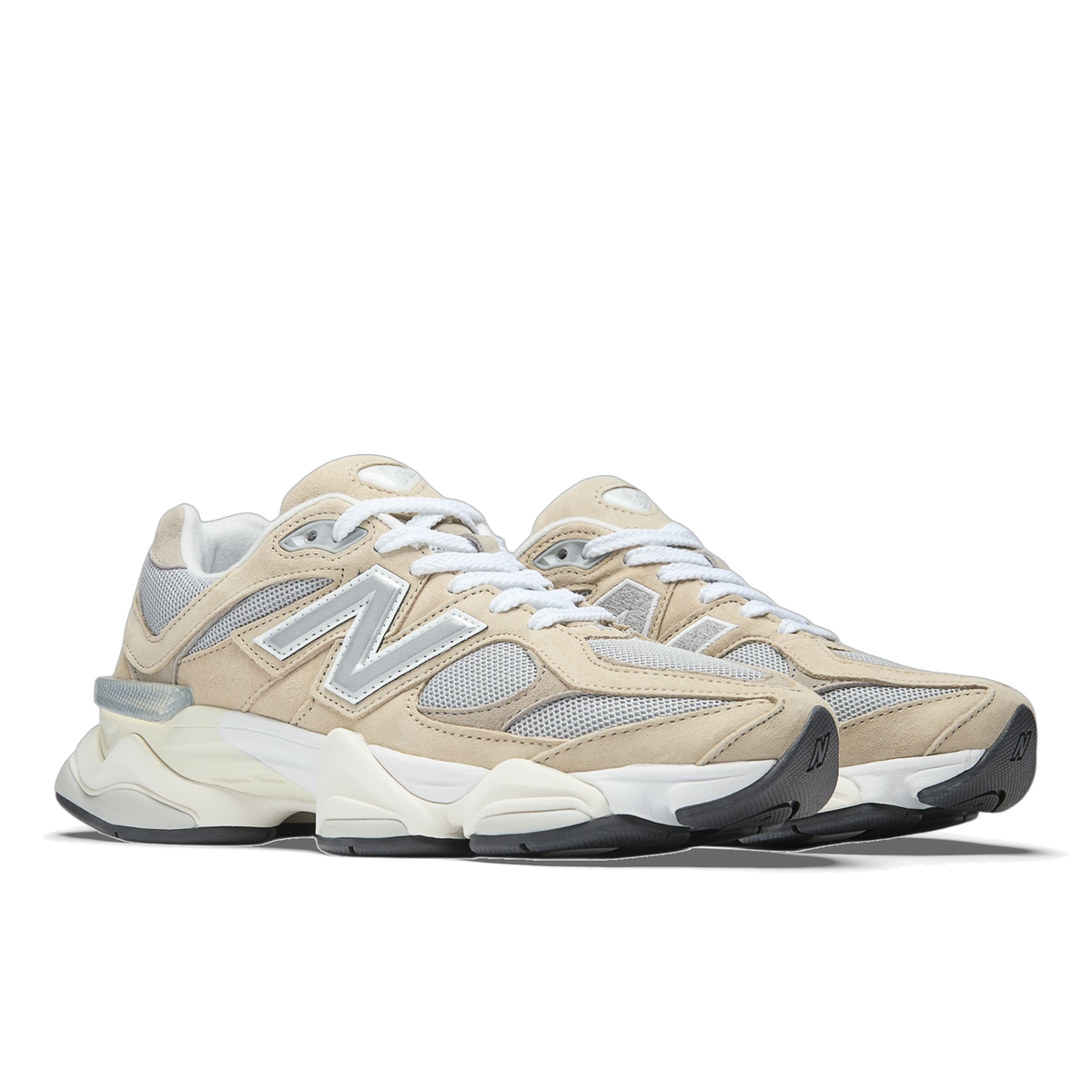 Pair of New Balance 9060 sneakers in beige suede with grey mesh panels, white laces, silver N logo, and a white and cream chunky sole with black outsole.