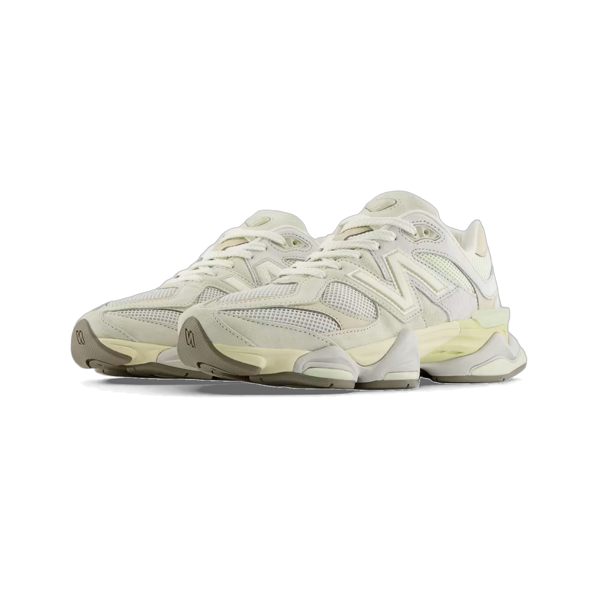 Pair of off-white New Balance 9060 sneakers with suede and mesh panels and a chunky gray midsole, shown at a front-angled view facing left.