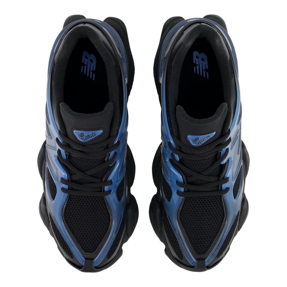Top-down view of a pair of New Balance 9060 sneakers in navy and black with blue gradient overlays and black laces and mesh tongue