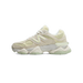 Side view of a beige and pale green New Balance 9060 sneaker with toe pointing left, showing the N logo and chunky midsole