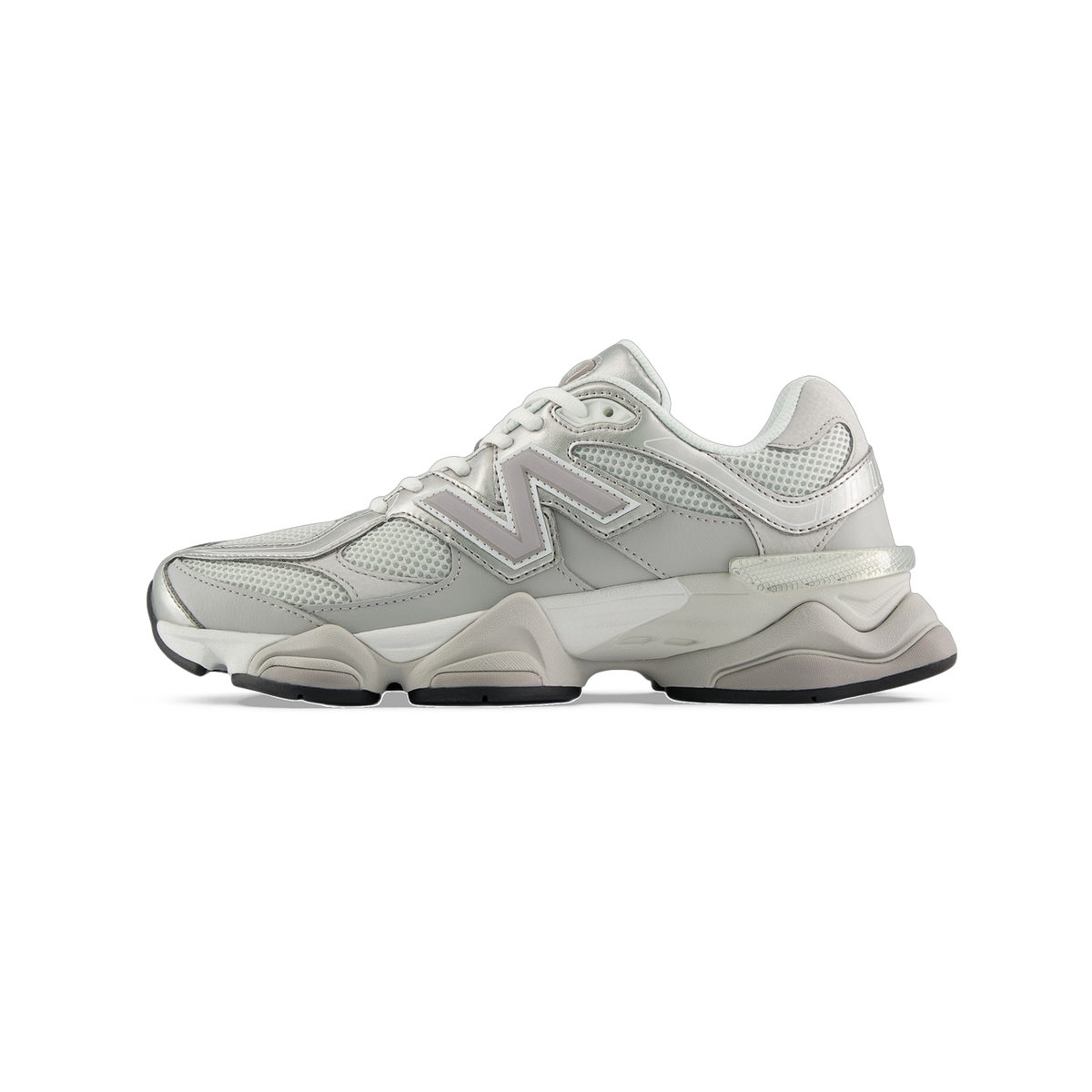 Side view of a light gray New Balance 9060 sneaker with mesh panels, metallic silver accents, and a chunky white midsole.