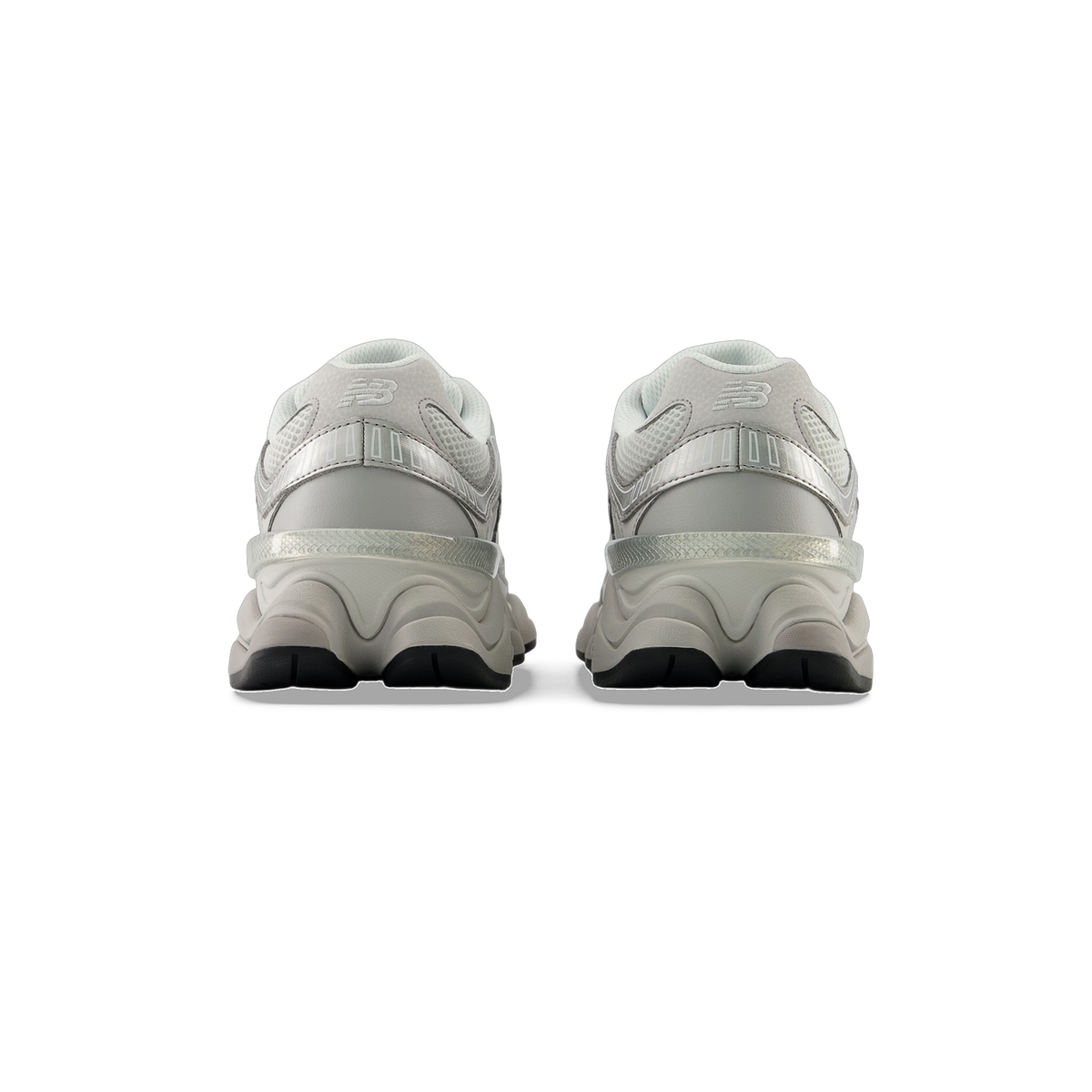 Rear view of a pair of gray New Balance 9060 sneakers showing the heel pull tabs, ridged sole design, and black outsoles.