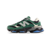 Side view of a green suede New Balance 9060 sneaker with black mesh panels, grey N logo, cream accents, and a chunky black midsole with blue outsole details.