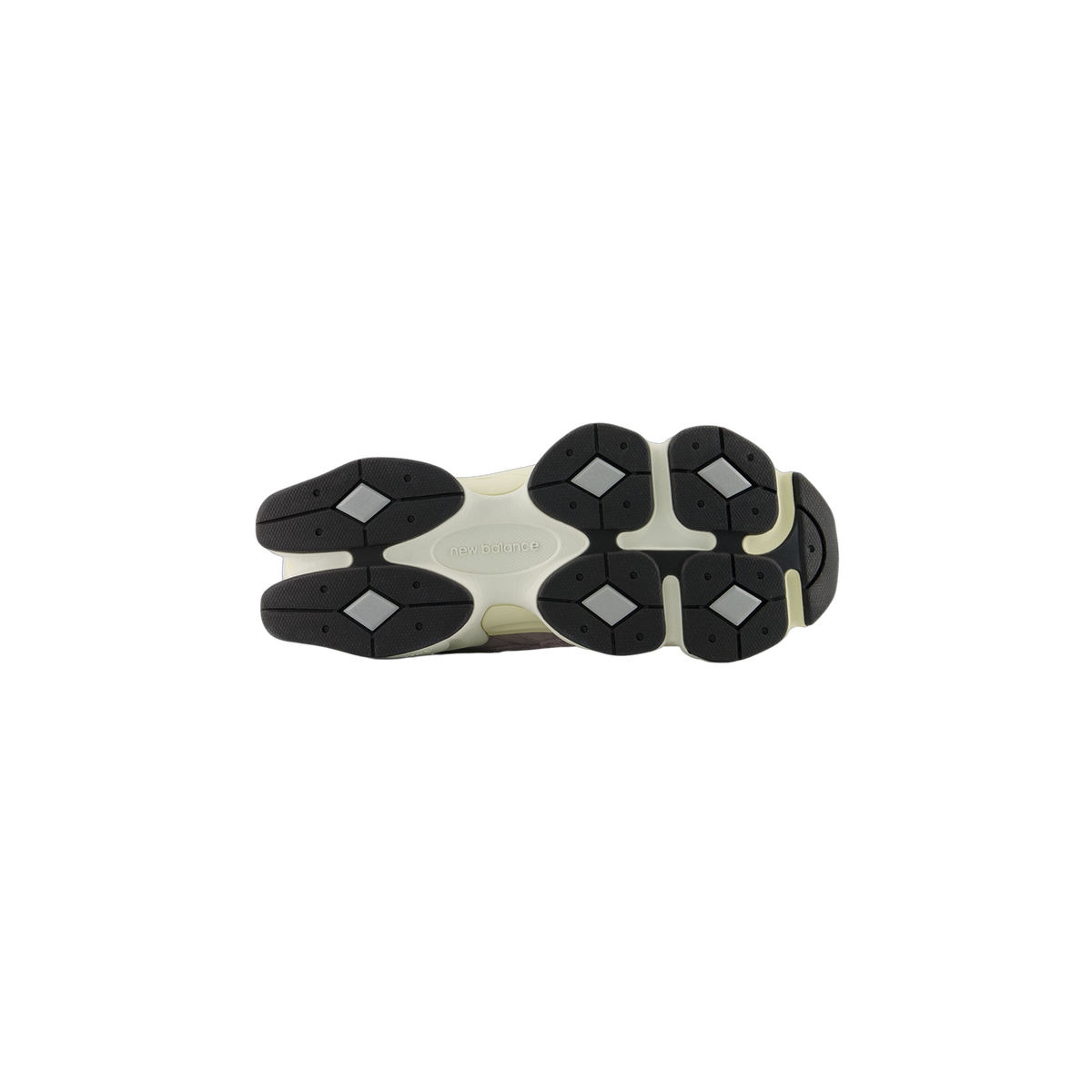 Bottom view of a New Balance 9060 sneaker showing a cream outsole with black lug tread pads and diamond-shaped accents, with the New Balance logo in the arch area.