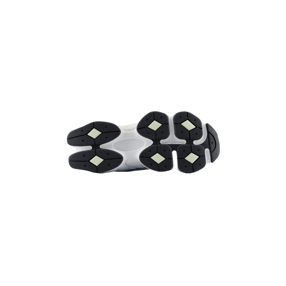 Bottom view of a New Balance 9060 sneaker showing a white outsole with black lobed tread segments and the New Balance logo molded in the center arch.