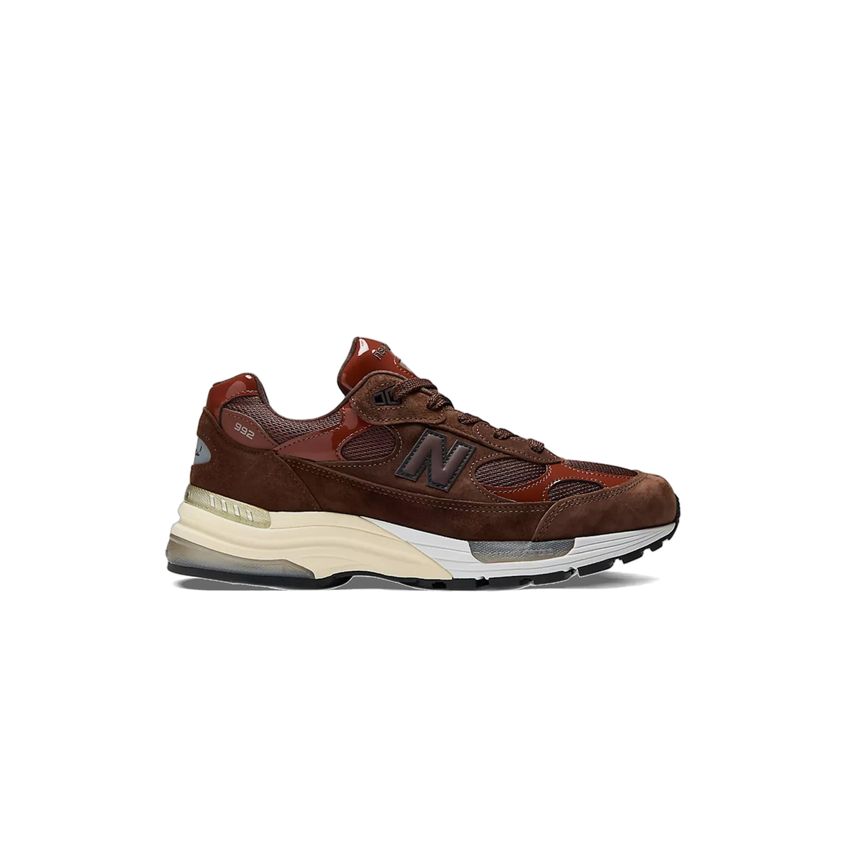 Side view of a brown New Balance 992 sneaker with reddish-brown mesh panels, suede overlays, dark N logo, and a cream and white midsole with black outsole, toe pointing left.
