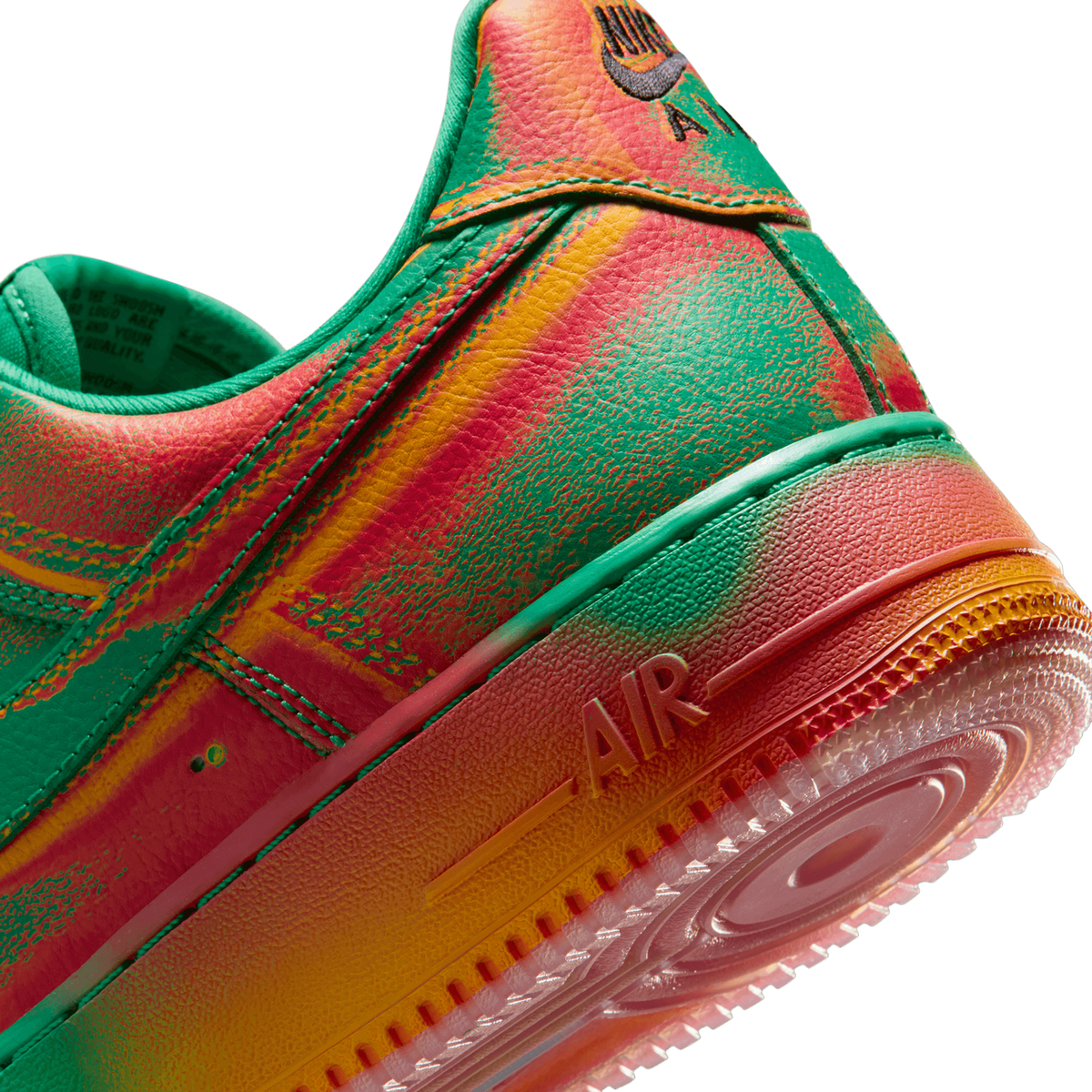 Close-up angled view of a Nike Air Force 1 heel and midsole showing a green, red, and orange tie-dye style print with Air Force branding on the sole and embroidered Nike Air logo on the heel tab