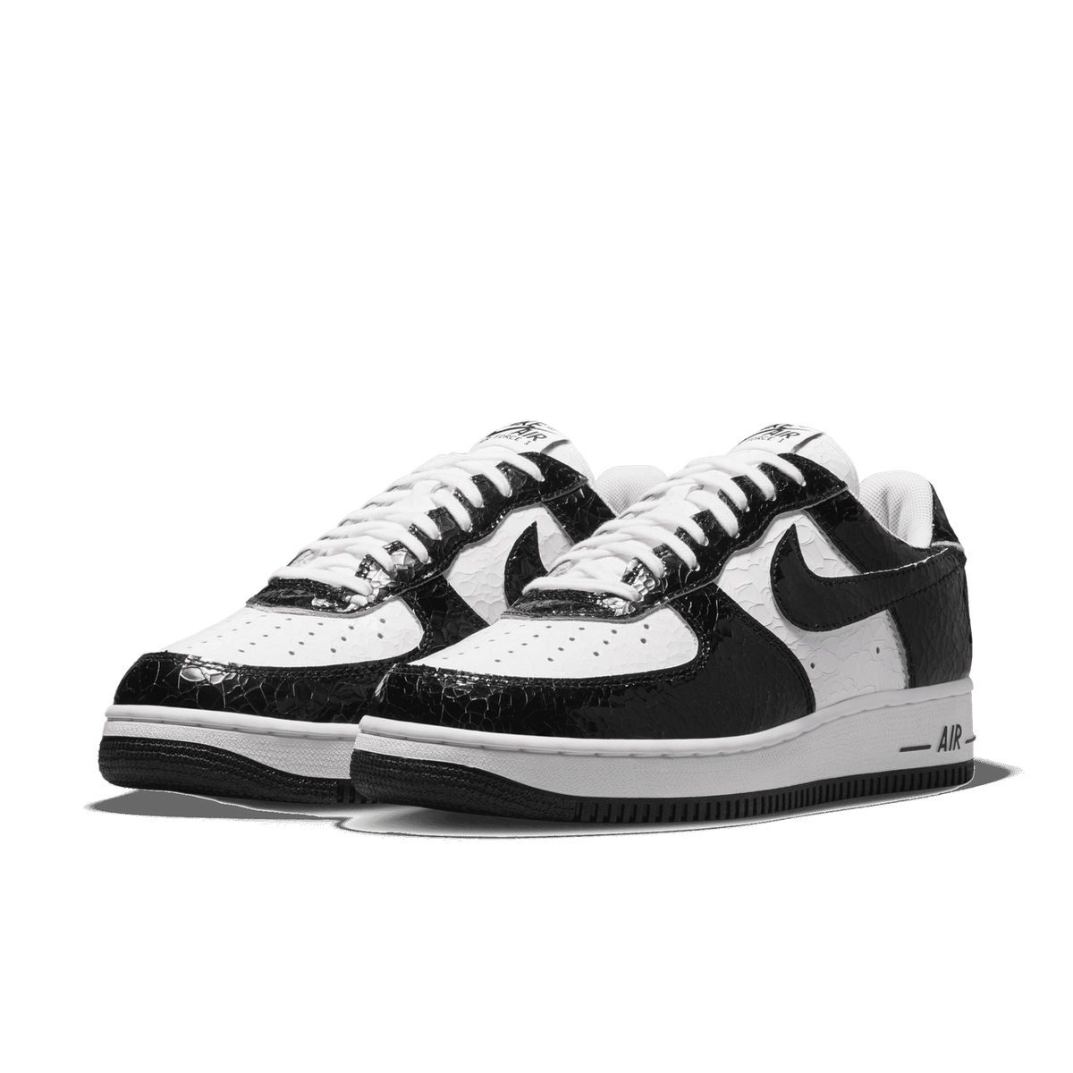 Pair of black and white Nike Air Force 1 Low sneakers with a cracked patent leather texture, angled toward the left showing the side swoosh and white midsole.
