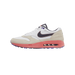 Right side view of a white and tan Nike Air Max 1 '86 golf shoe with a navy swoosh, coral midsole and visible Air bubble unit, and purple accents on the outsole.