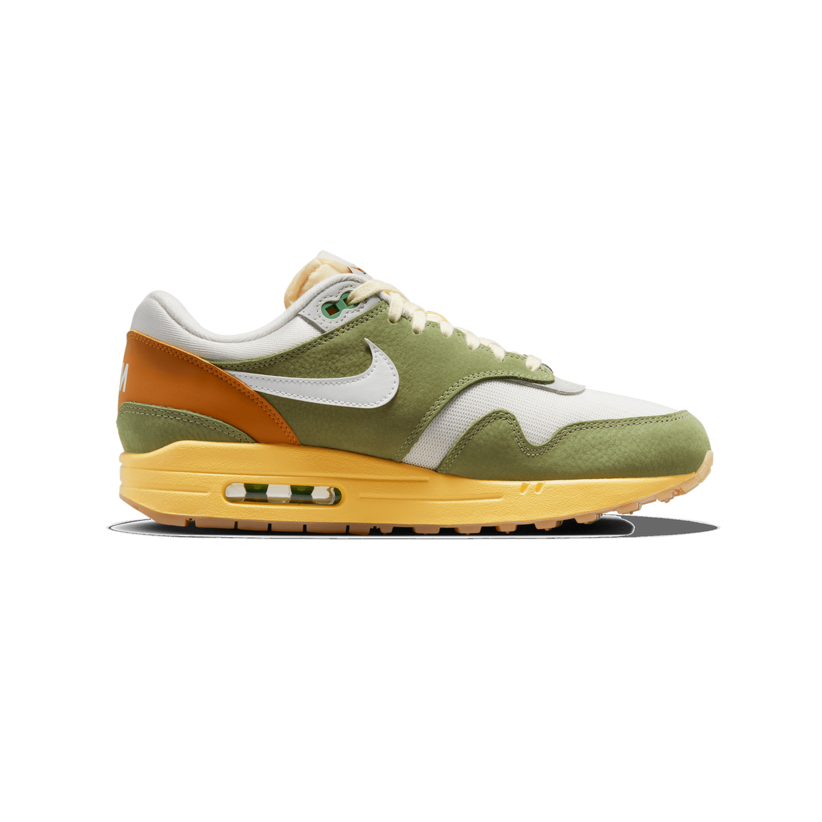 A single green, white and orange Nike Air Max 1 sneaker viewed from the outside, toe pointing left, showing the green suede overlays, white mesh panel, white Swoosh logo, orange heel, and yellow Air Max sole with a visible clear air unit.