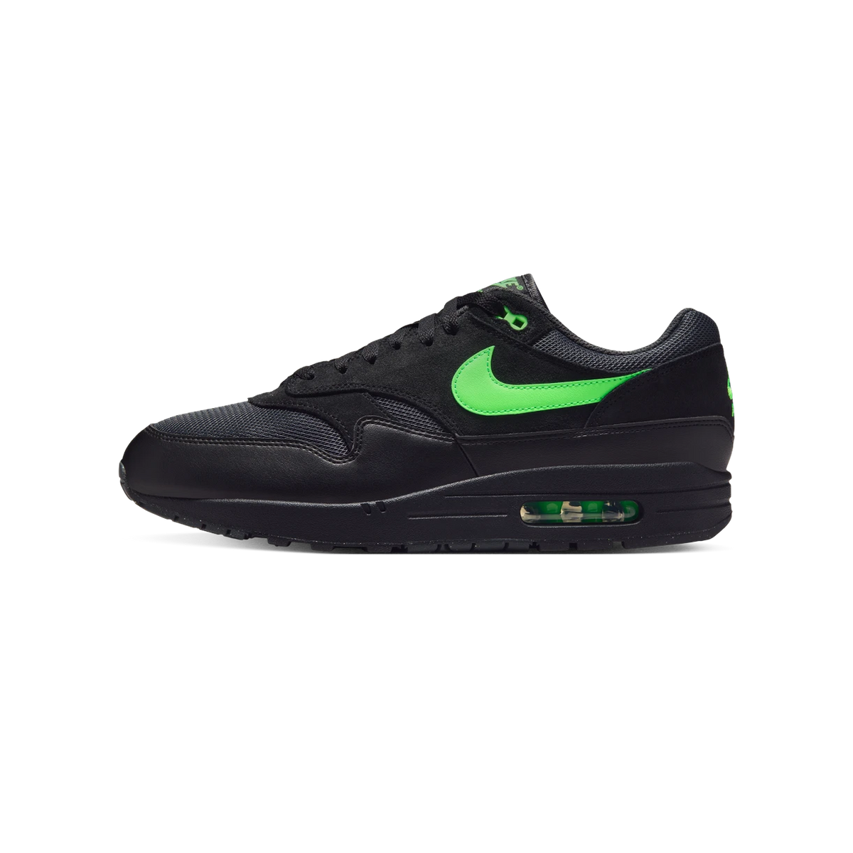 Left Nike Air Max 1 sneaker in black with a green swoosh and visible green Air unit, shown from the side with toe pointing left