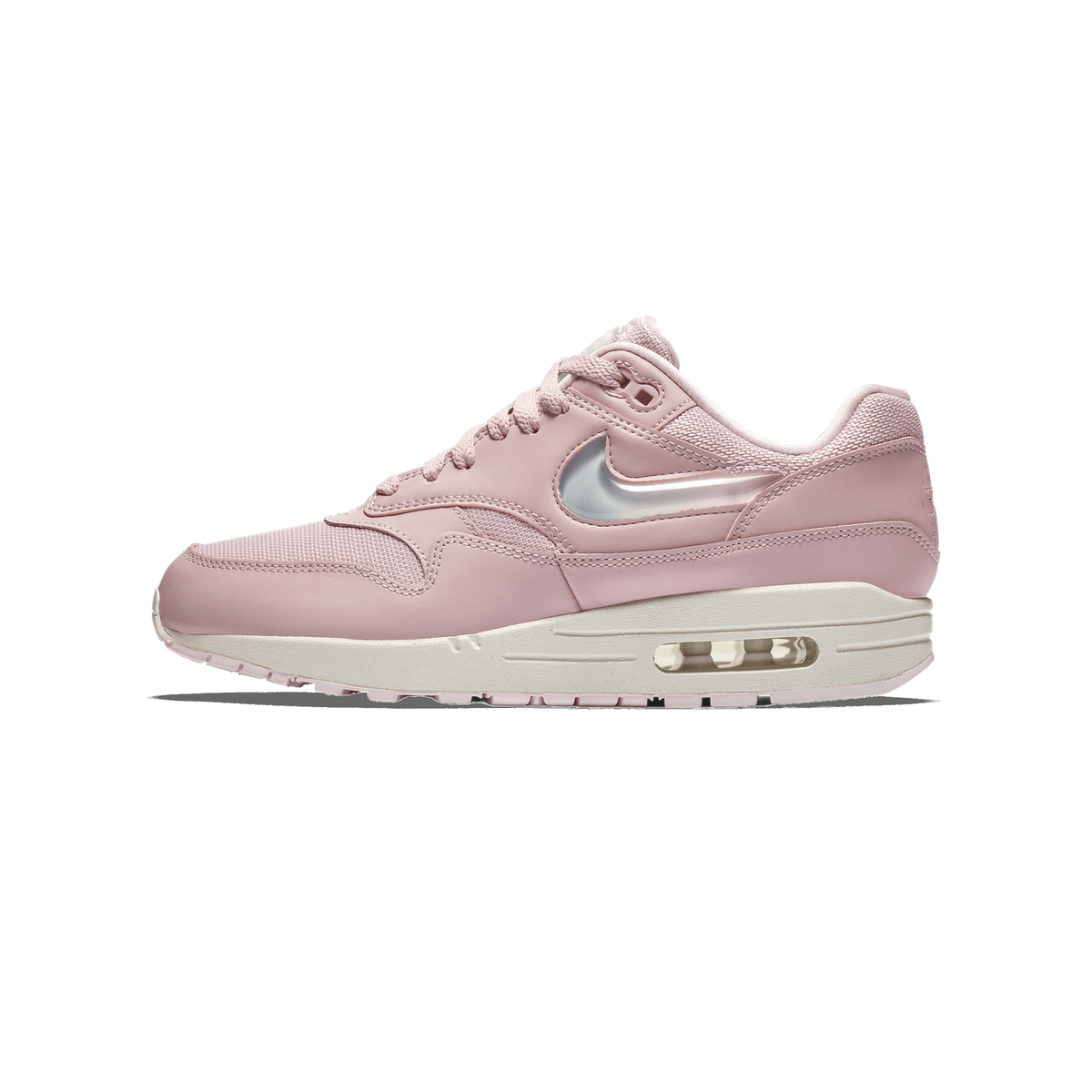 Side view of a pink Nike Air Max 1 sneaker with a translucent pink Jelly Swoosh, pale pink mesh and leather upper, and an off-white midsole showing a visible Air unit, with the toe pointing left.