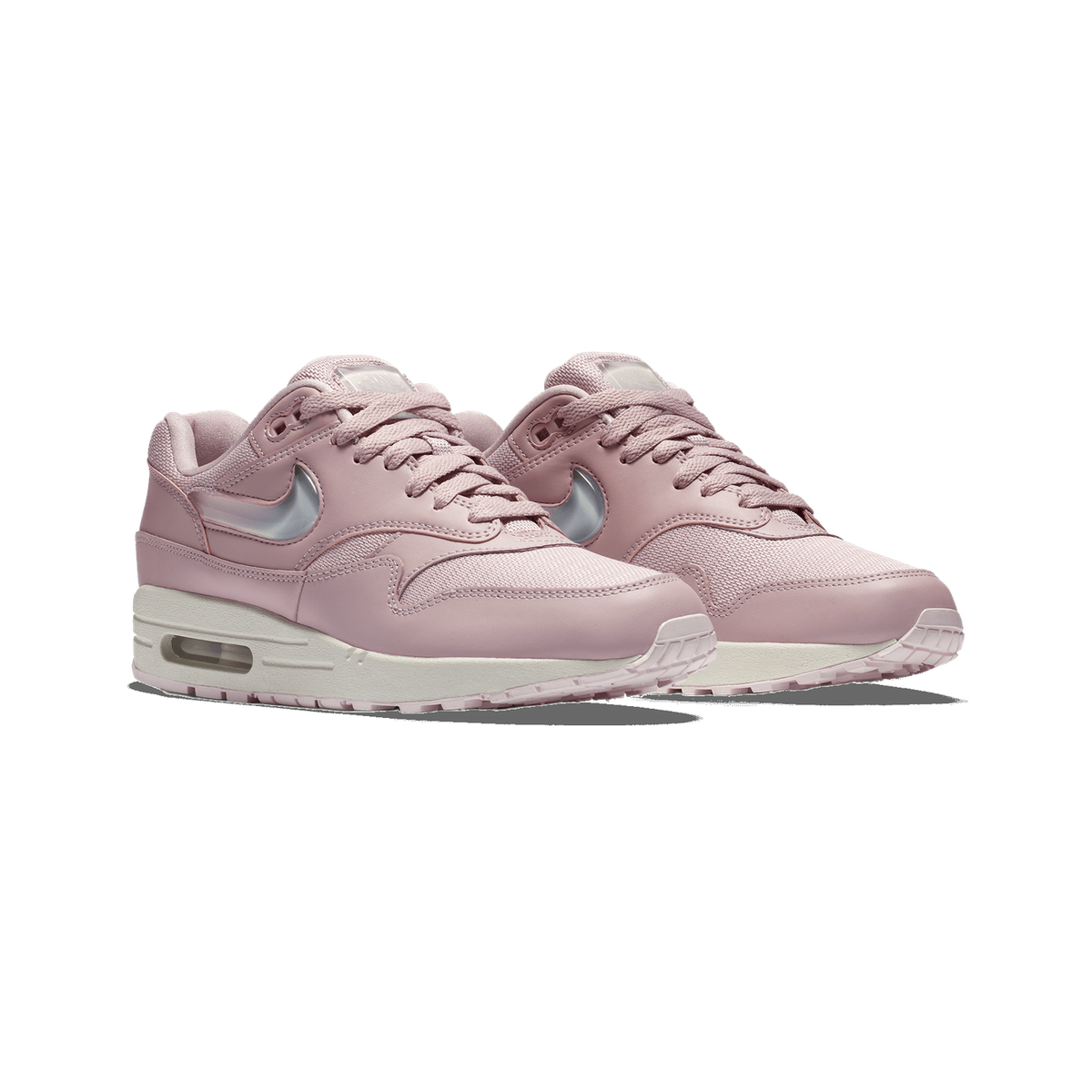 A pair of pink Nike Air Max 1 sneakers with clear jelly Swoosh logos and white midsoles, shown side by side angled to the left on a white background.