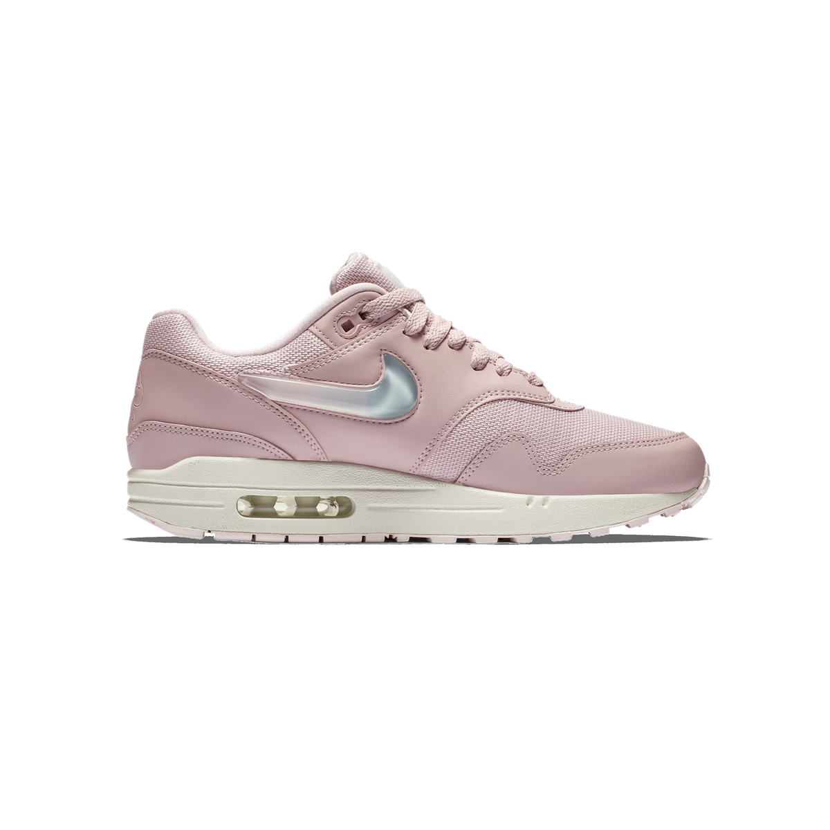 Side view of a single pink Nike Air Max 1 sneaker with its toe pointing left, showing a translucent jelly Swoosh logo on the side, a pale pink mesh and leather upper, and a white midsole with a visible Air unit.