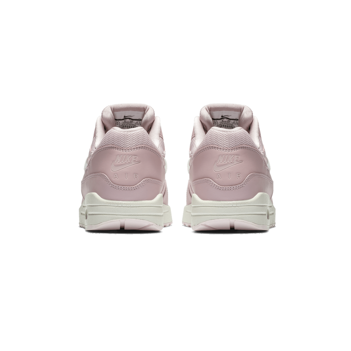 Rear view of a pair of pale pink Nike Air Max 1 sneakers standing side by side, showing the heel counters with embossed Nike and Air logos, the pull tabs, and the cream-colored midsoles.
