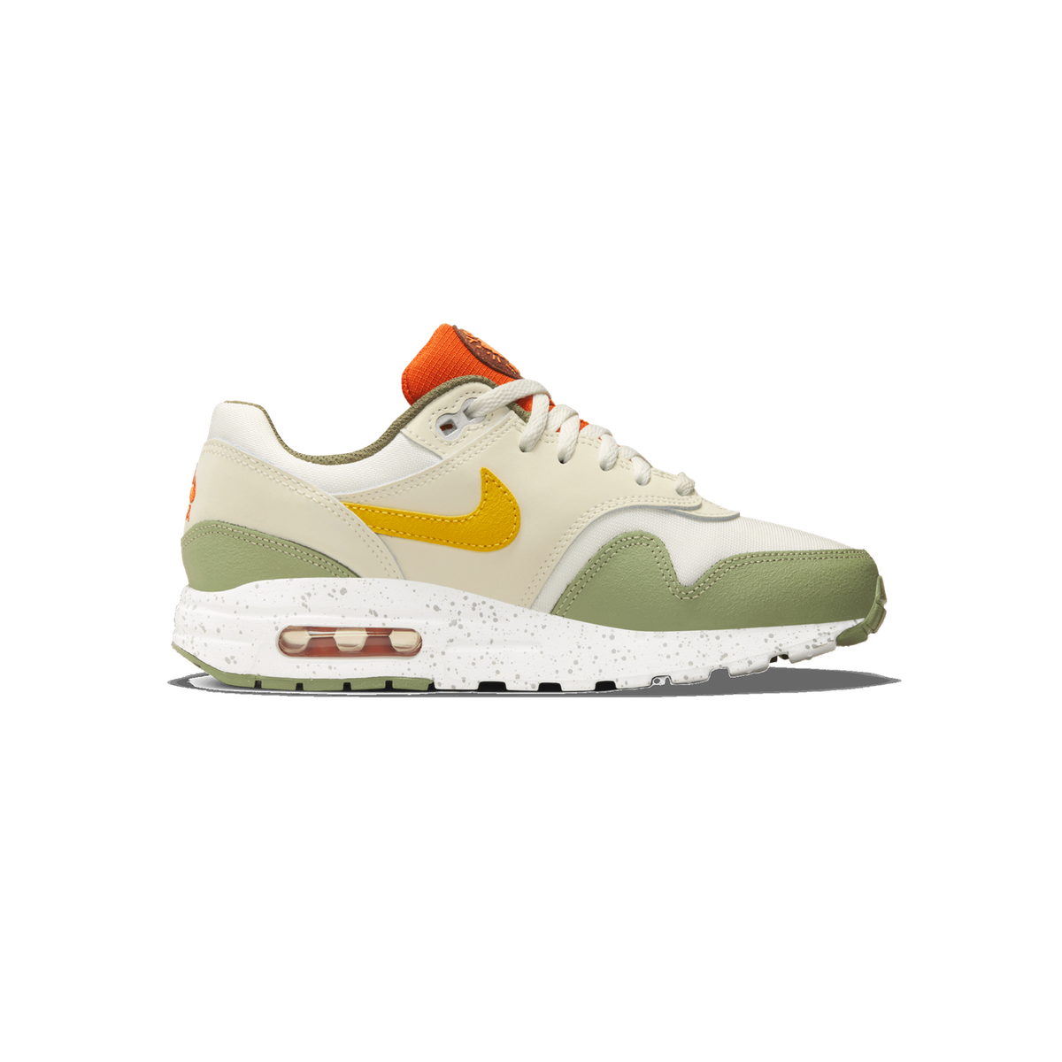 Side profile of a single Nike Air Max 1 sneaker with the toe pointing left, showing a cream and sail upper, olive-green toe and heel overlays, a mustard-yellow Swoosh, an orange tongue pull tab, and a speckled white midsole with a visible orange Air