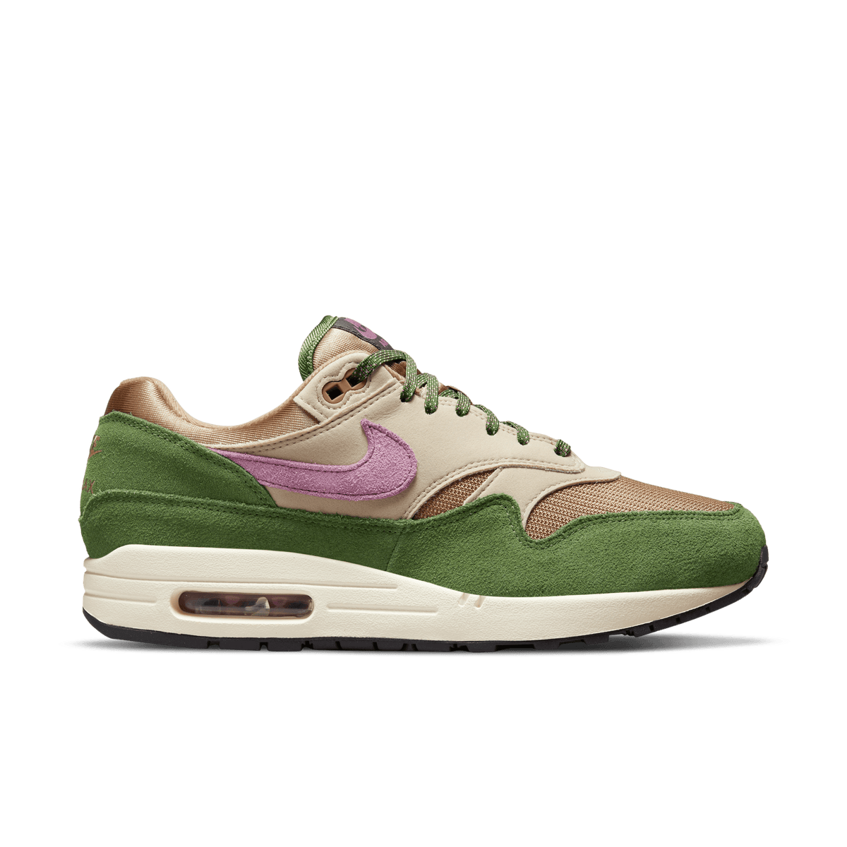 Left Nike Air Max 1 sneaker in side profile with green suede overlays, tan upper, purple swoosh, and cream midsole, toe pointing left