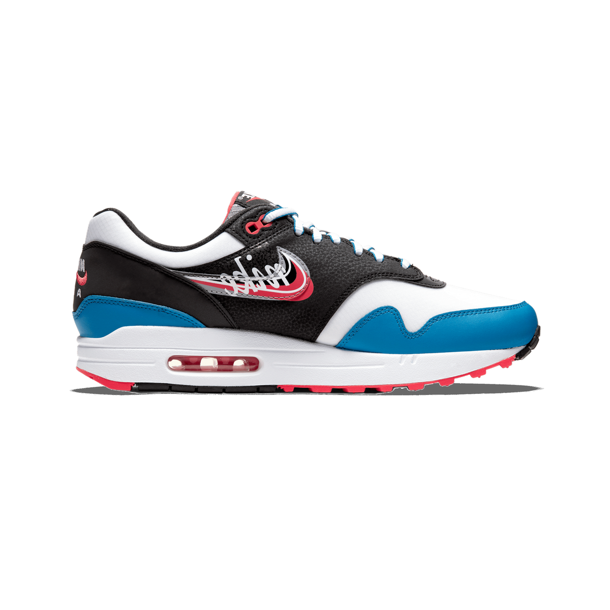 Side profile of a Nike Air Max 1 sneaker with the toe pointing left, showing a white midsole with a visible red Air unit, blue toe and heel overlays, black and white upper with a script Nike logo, and red accents on the heel tab and outsole lugs.