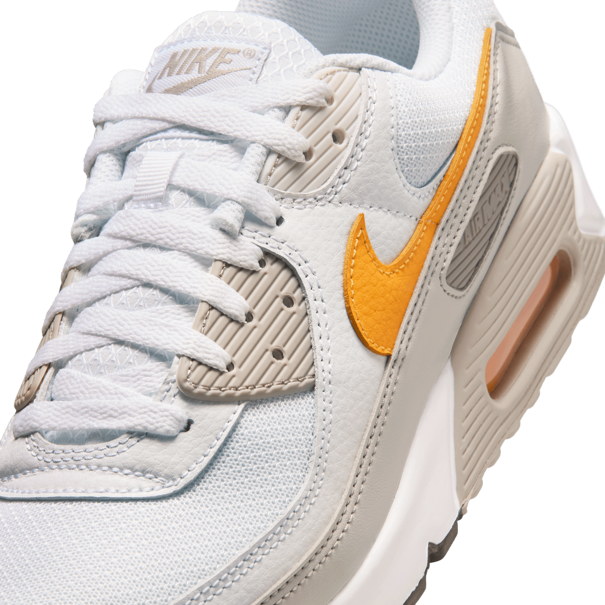 Close-up angled view of a white Nike Air Max 90 showing the orange swoosh, laces, and Nike-branded tongue.
