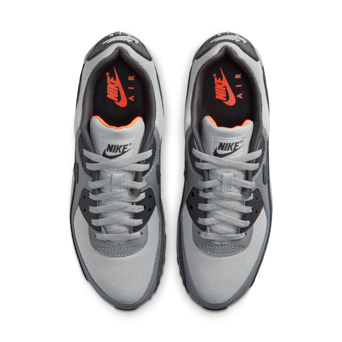 Top-down view of a pair of grey and black Nike Air Max 90 sneakers with orange Nike Air branding visible inside the tongue.