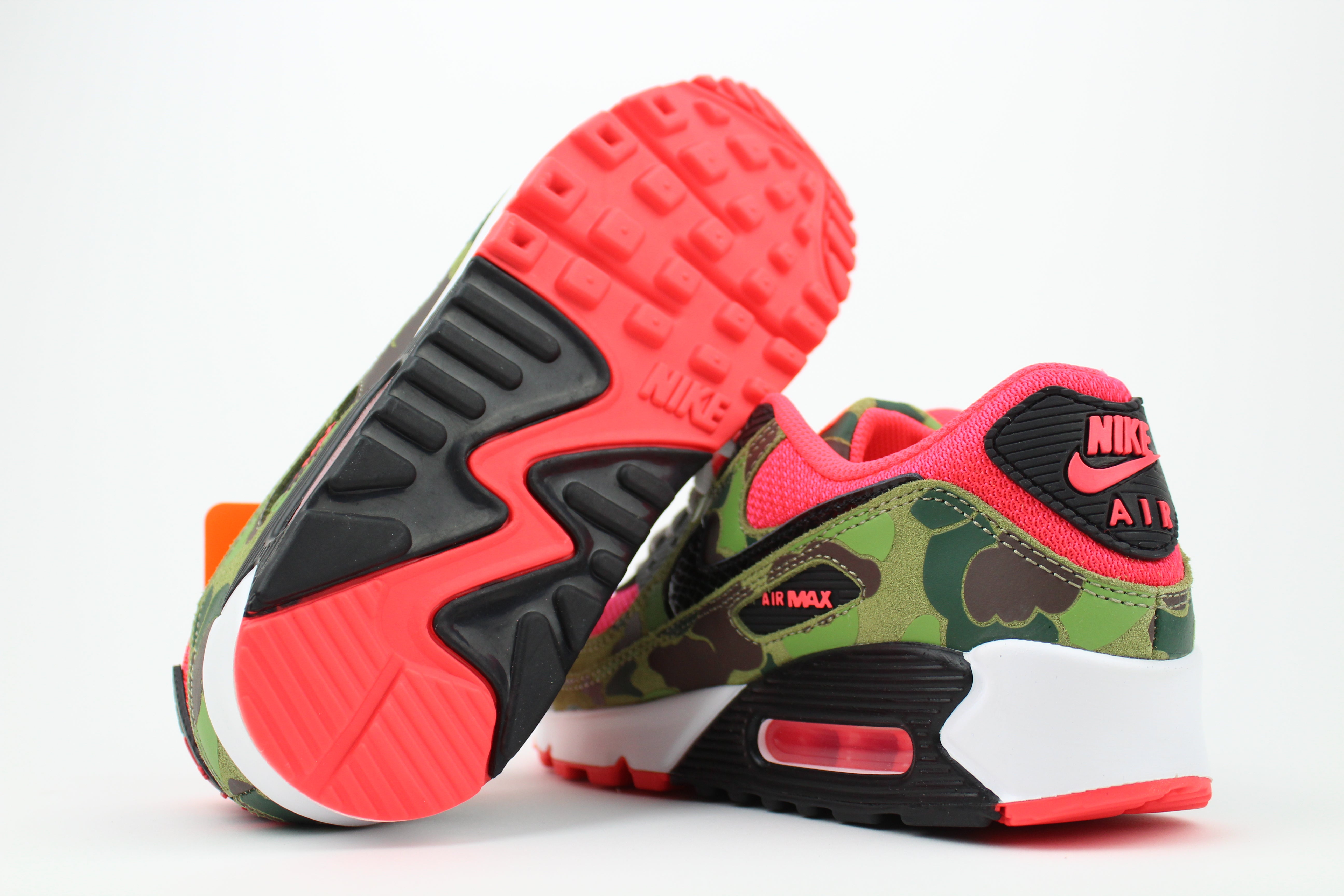 Close-up of Nike Air Max 90 'Reverse Duck Camo' sneaker, featuring bold reverse camo pattern, vibrant color accents, and signature Air cushioning, ideal for fashion-forward sneaker enthusiasts and collectors.