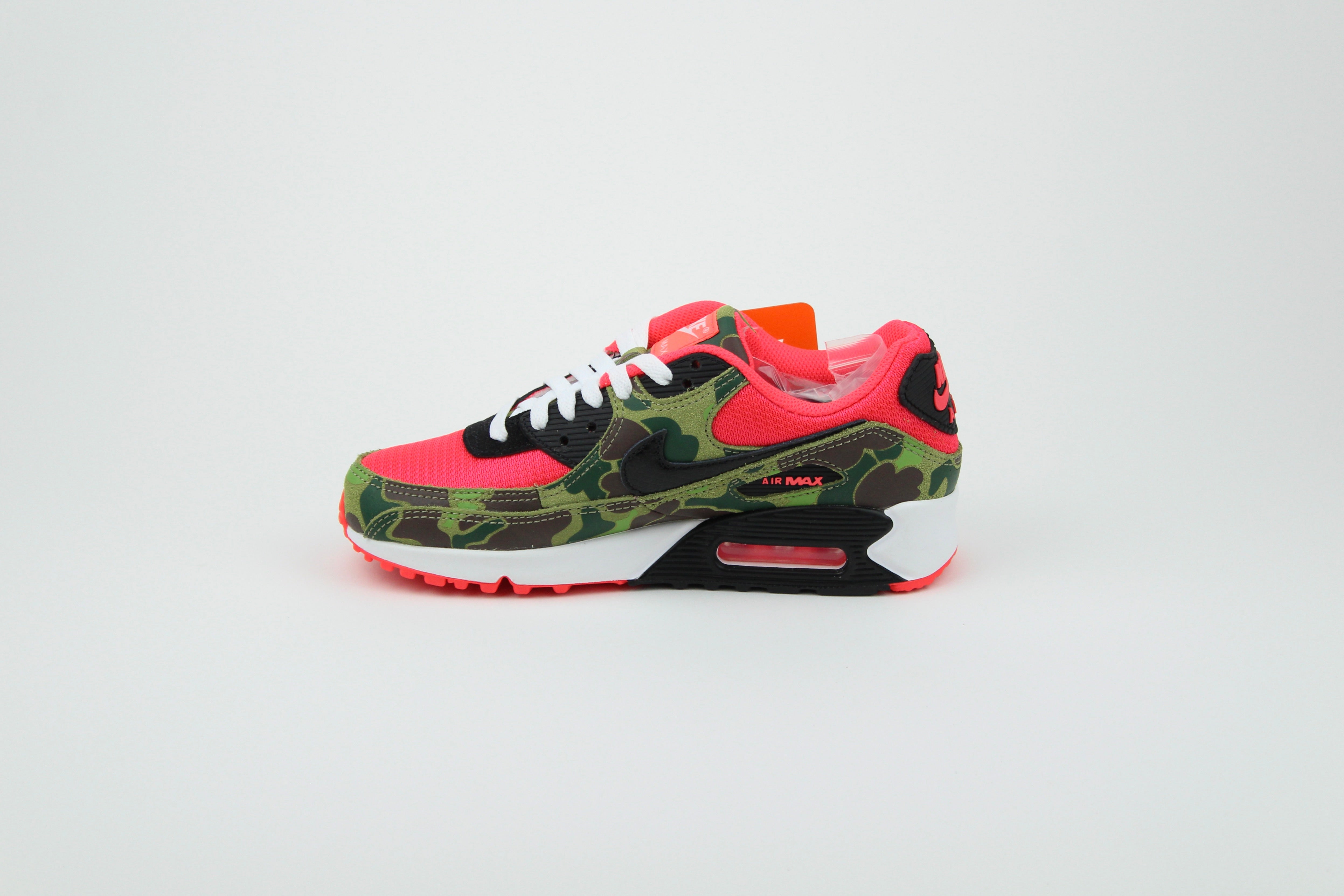 Close-up of Nike Air Max 90 'Reverse Duck Camo' sneaker, featuring bold reverse camo pattern, vibrant color accents, and signature Air cushioning, ideal for fashion-forward sneaker enthusiasts and collectors.