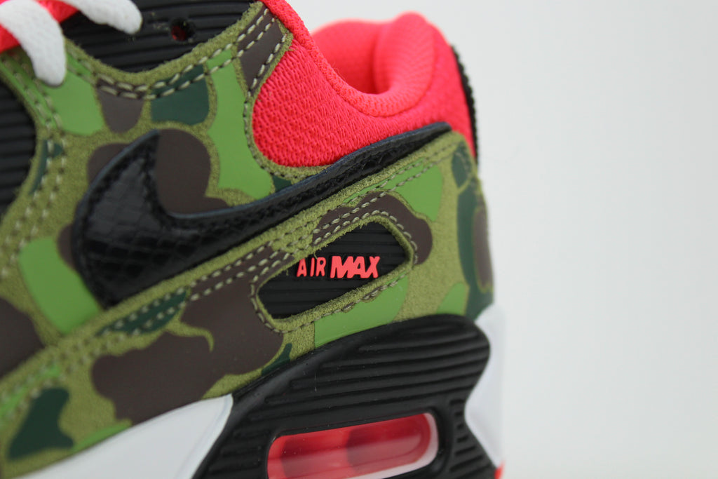Close-up of Nike Air Max 90 'Reverse Duck Camo' sneaker, featuring bold reverse camo pattern, vibrant color accents, and signature Air cushioning, ideal for fashion-forward sneaker enthusiasts and collectors.