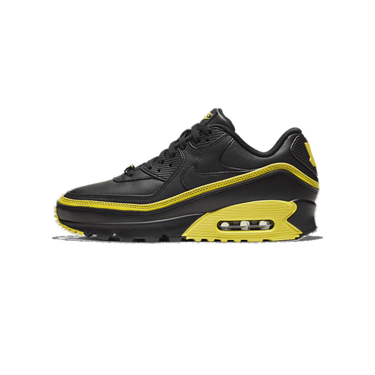 Side view of a black Nike Air Max 90 Undefeated sneaker with yellow piping, swoosh outline, and visible air unit in the yellow midsole, toe pointing left
