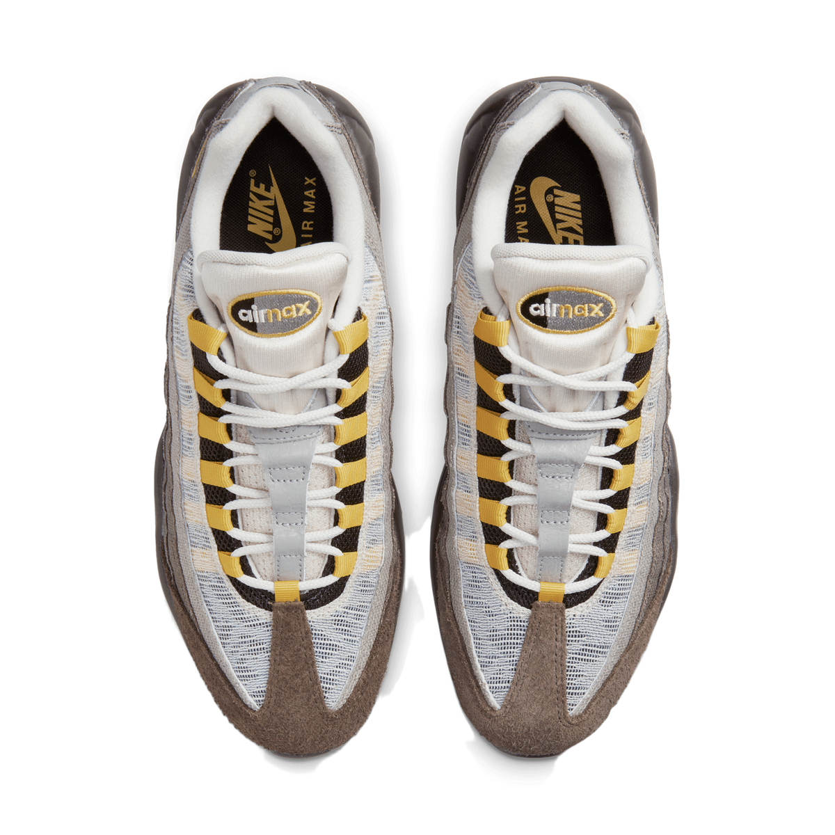 Top-down view of a pair of Nike Air Max 95 sneakers placed side by side with toes pointing toward the bottom of the frame, showing grey and off-white mesh panels, brown suede toe and heel overlays, yellow laces and heel tabs, and black tongue and col