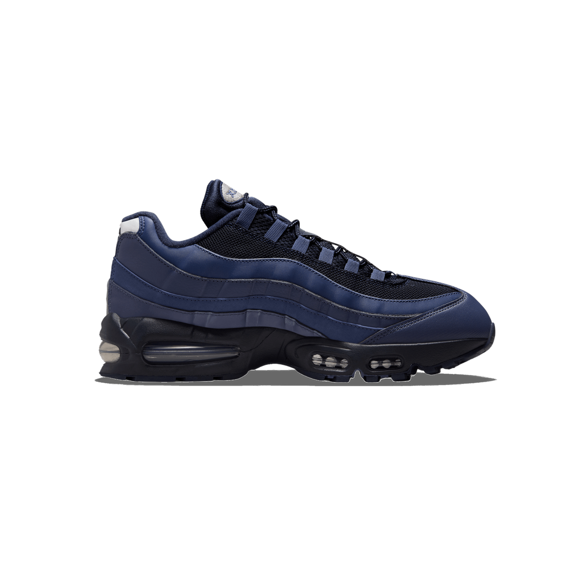 Side profile of a navy blue Nike Air Max 95 sneaker with the toe pointing left, showing navy and dark mesh upper panels, a grey heel tab, and visible clear Air units in the black midsole.